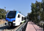 This train is heading away from Redlands ESRI Station toward the next stop of Redlands Downtown Sta